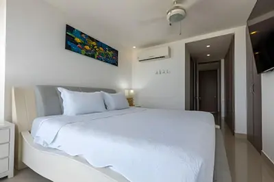 a white bedroom with a large white bed in it at Hermoso Apto Frente al Mar - Morros City 801 in Cartagena de Indias