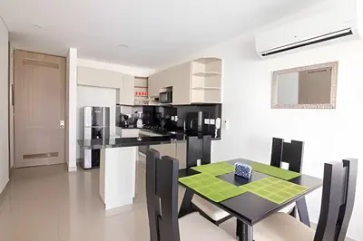 a kitchen with a black table and chairs in a room at Lujoso Apto de 1 Hab en Piso 7 - Infinitum in Cartagena de Indias