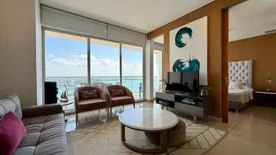 a living room with a couch and a tv and a bed at H2 Lujoso Apto 1 Hab Piso 23 Compl. Empleada in Cartagena de Indias