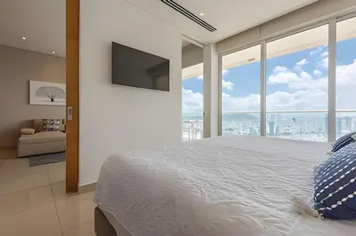 a bedroom with a large bed with a flat screen tv at ¡Espectacular Vista a la bahía! Piso 26 H2 Hyatt in Cartagena de Indias