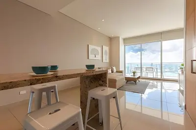 a kitchen with a counter and stools in a room at ¡Espectacular Vista a la bahía! Piso 26 H2 Hyatt in Cartagena de Indias