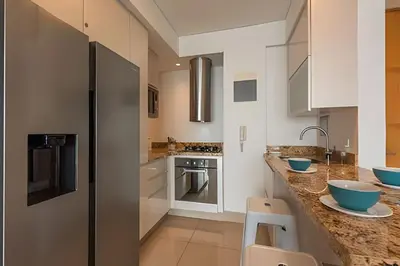 a kitchen with white cabinets and blue bowls on the counter at ¡Espectacular Vista a la bahía! Piso 26 H2 Hyatt in Cartagena de Indias