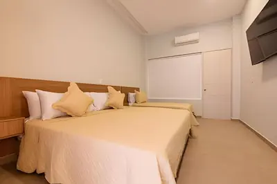 a bedroom with a large bed with yellow pillows at Apto con balcón en en Centro Historico - Zaher G in Cartagena de Indias