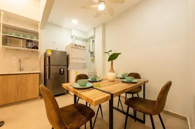 a kitchen and dining room with a wooden table and chairs at Apto con balcón en en Centro Historico - Zaher G in Cartagena de Indias