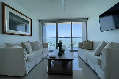 a living room with white furniture and large windows at Lujoso Apto de 2 Hab en piso 26 - Morros City in Cartagena de Indias