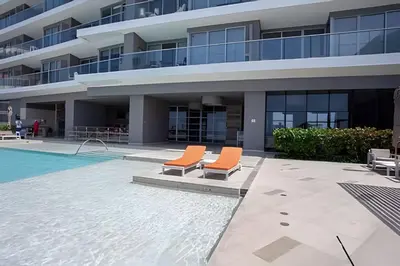 an apartment building with two chairs next to a swimming pool at Lujoso Apto de 2 Hab en piso 26 - Morros City in Cartagena de Indias