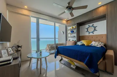 a bedroom with a bed and a clock on the wall at Piso 27 - Espectacular apartamento en Bocagrande in Cartagena de Indias