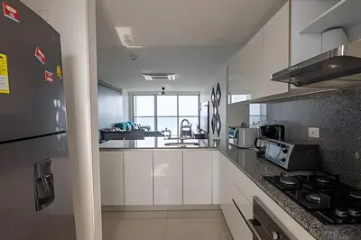 a kitchen with white cabinets and a stove top oven at Espectacular Apto de 2 Hab en Piso 27-Morros City in Cartagena de Indias