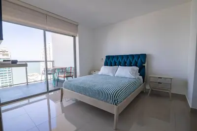 a bedroom with a bed and a large window at Infinitum Espectacular apto piso 28 vista al mar in Cartagena de Indias