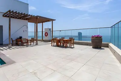 a patio with tables and chairs on top of a building at Lujoso Apto Vista al Mar Piso 34 - Palmetto Beach in Cartagena de Indias