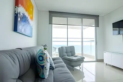 a living room with a gray couch and a chair at Lujoso Apto Vista al Mar Piso 34 - Palmetto Beach in Cartagena de Indias