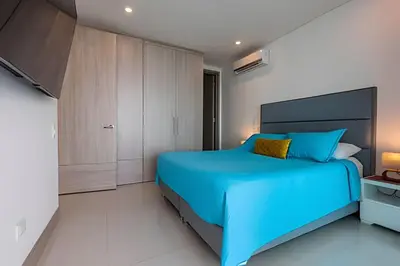a bedroom with a blue bed and cabinets at Palmetto Sunset piso 33 - Vista espectacular in Cartagena de Indias