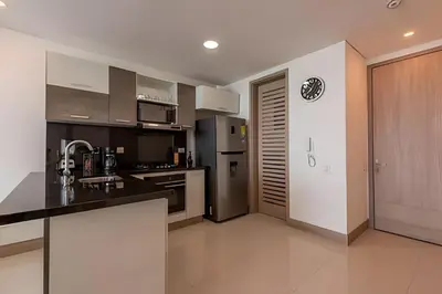 a kitchen with stainless steel appliances and black counter tops at Palmetto Sunset piso 33 - Vista espectacular in Cartagena de Indias