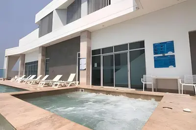 a swimming pool in front of a building with chairs at Palmetto Sunset piso 33 - Vista espectacular in Cartagena de Indias