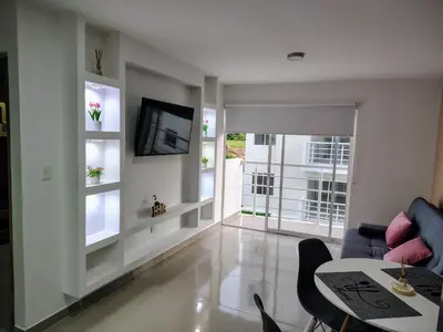 a living room with a television and a table and chairs at Apartamento exclusivo para unas vacaciones confortables in Coveñas