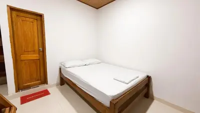 a small bed in a room with a door at Cabaña Datalu 3 in Coveñas