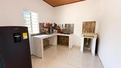 a kitchen with a black refrigerator and a sink at Cabaña Datalu 3 in Coveñas