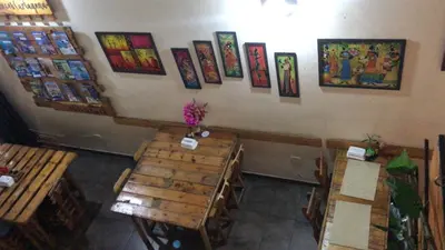 a restaurant with wooden tables and pictures on the wall at Habitación Privada con Ventilador in Cartagena de Indias
