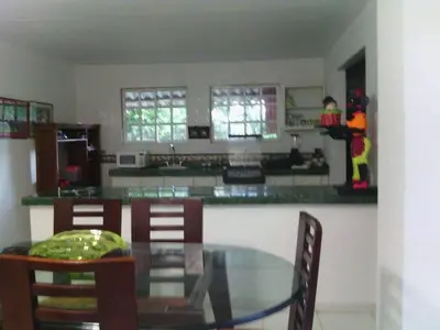 a dining room with a glass table and a kitchen at Casafinca en Arjona # 3 in Cartagena de Indias