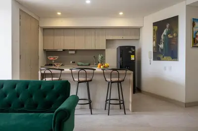 a kitchen with a counter and stools in a room at Modern apt near the beach with Jacuzzi, Cartagena in Cartagena de Indias