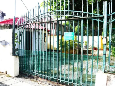 a green fence with a sign on it at Comfortable and quiet apartment in Cartagena de Indias