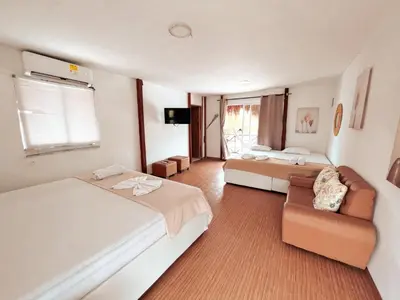 a large bedroom with two beds and a couch at Margarita's Beach Club in Playa Punta Arena