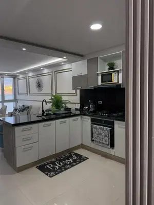 a kitchen with white cabinets and a stove top oven at Apartamento en Palmetto sunset frente al mar piso 20 in Cartagena de Indias