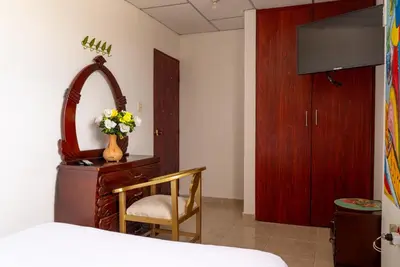 a bedroom with a dresser with a mirror and a chair at Donde Mire in Puerto Colombia