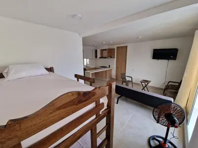 a bedroom with a large bed and a kitchen at Apartamento en Cartagena, Manzanillo in La Siriaca