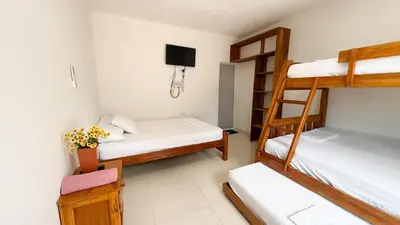 a room with three bunk beds and a television at Cabaña Datalu 2 in Coveñas