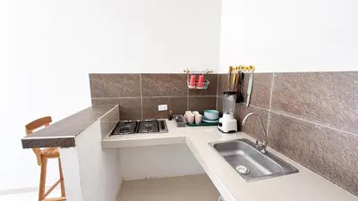 a small kitchen with a sink and a stove at Cabaña Datalu 2 in Coveñas