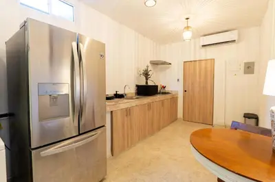 a kitchen with a stainless steel refrigerator and a wooden table at Oasis Colonial Cartagena in Cartagena de Indias