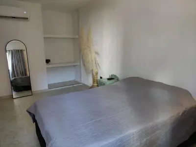 a white bedroom with a bed and a mirror at Oasis Colonial Cartagena in Cartagena de Indias