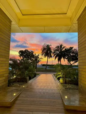 a walkway with palm trees and a sunset in the background at by Calamari Homes - Murano Elite 1901 Bocagrande in Cartagena de Indias