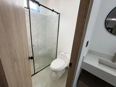 a bathroom with a toilet and a glass shower at Coral Tower in Barranquilla