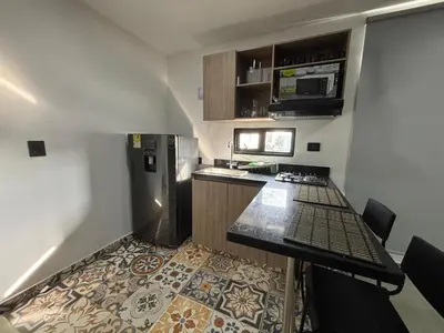 a small kitchen with a stove and a refrigerator at Coral Tower in Barranquilla