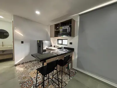 a kitchen with a counter and stools in a room at Coral Tower in Barranquilla