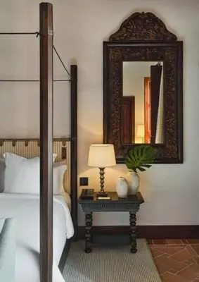 a bedroom with a bed and a table with a mirror at Four Seasons Hotel & Residences Cartagena in Cartagena de Indias