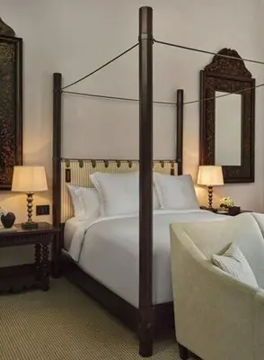 a bedroom with a large bed and a chair at Four Seasons Hotel & Residences Cartagena in Cartagena de Indias