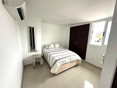 a bedroom with a bed in a white room at Dubai 202 in Barranquilla