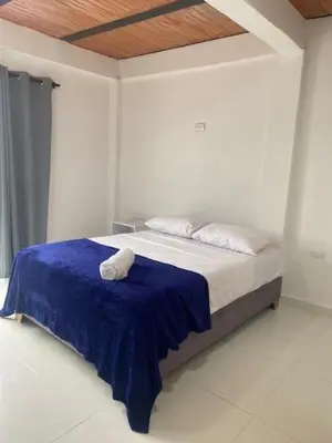 a bedroom with a bed with a blue blanket at Casa Mariana Hostel Boutique in Santa Marta