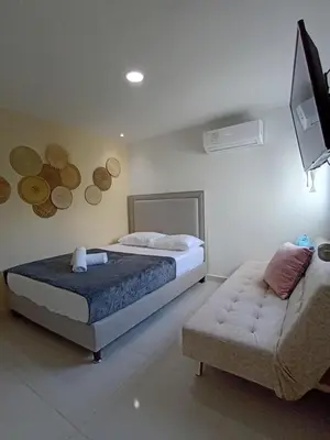 a bedroom with a bed and a couch at Apartamento primer piso Olamar Coveñas in Coveñas