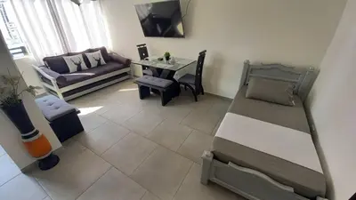 a living room with a bed and a couch and a table at Apartamento Cerca a la playa, Piscina, Wifi, AC in Cartagena de Indias
