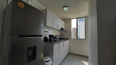 a kitchen with a stainless steel refrigerator and white cabinets at Apartamento Cerca a la playa, Piscina, Wifi, AC in Cartagena de Indias