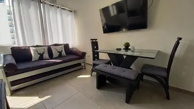 a living room with a table and a couch and a table and chair at Apartamento Cerca a la playa, Piscina, Wifi, AC in Cartagena de Indias