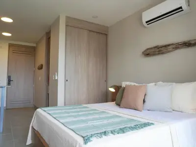 a bedroom with a large white bed with pillows at Santa Marta apartamento frente al mar -Santamarina- 1202 in Santa Marta
