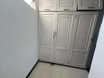 a kitchen with white cabinets and a tiled floor at Tarapaca in Barranquilla