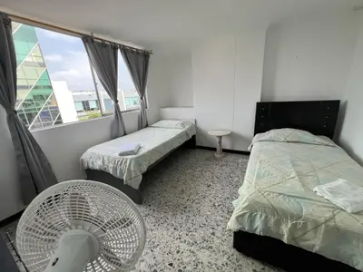 a room with two beds and a fan in it at Tarapaca in Barranquilla