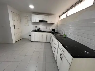 a kitchen with white cabinets and a black counter top at Tarapaca in Barranquilla
