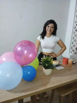 a woman standing next to a table with balloons at Casa 1811 in Cartagena de Indias